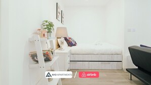 A modern bedroom with a bed, bedside table, lamp, and a small plant. - Modern Sheffield Studio With WiFi – APT 15 (Sheffield)