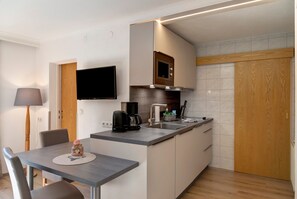 A compact kitchen with a built-in microwave, a coffee maker, and a sink. - Apartment 'Top 5' with Mountain View, Balcony and Wi-Fi (Oetz)