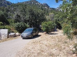 A car parked on a gravel road with a mountainous backdrop. - Holiday Home Viki (Korčula)