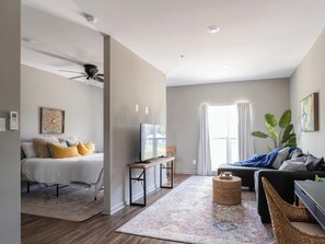 A modern living room with a bed, a sofa, a coffee table, and a TV. - 1BR near Downtown Bryan & Texas A&M (Bryan)