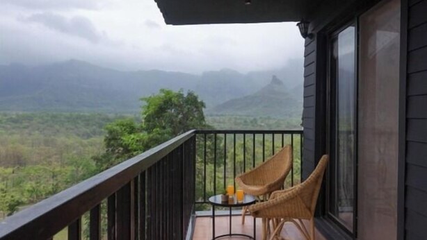 Uma varanda com vista para uma paisagem montanhosa.