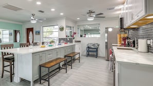 A modern kitchen with a central island, built-in appliances, and ample counter space. - Ocean View, Pool & Boat Dock: Indian Rocks Retreat (Indian Rocks Beach)