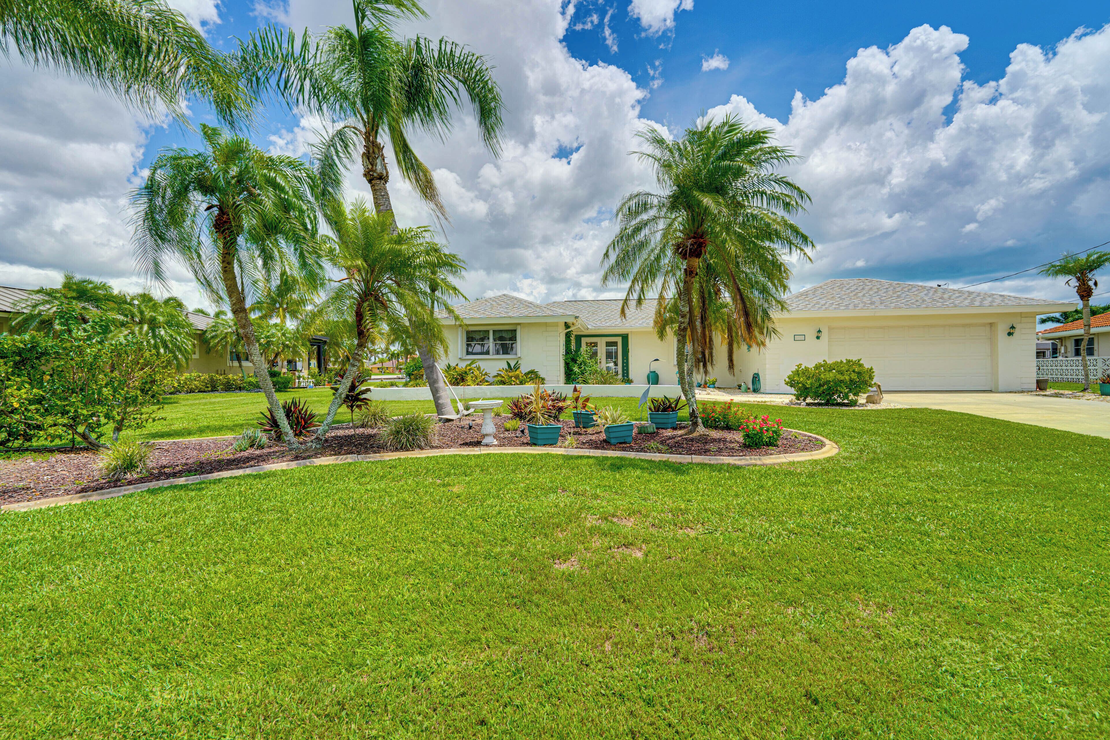 A well-maintained lawn with palm trees and a building with a light-colored facade.