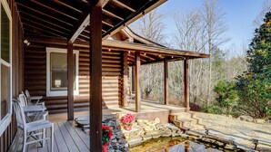 A wooden cabin with a covered porch, stone steps, and a small pond. - Pet-friendly Gatlinburg Cabin w/ Hot Tub! (Gatlinburg)