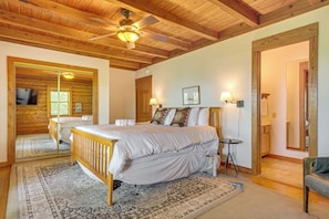 A bedroom with a wooden ceiling, a bed, a bedside table, a lamp, and a mirror. - 2 Mi to Ober Mtn: Hot Tub & Deck at Cozy Cabin! (Gatlinburg)