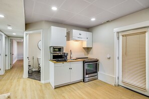 A compact kitchen with white cabinets, a microwave, a stove, and a sink. - 2 Mi to Des Moines Beach Park: Mod Des Moines Apt (Des Moines)