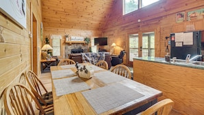 A wooden cabin interior with a dining area, kitchen, and living space. - Private Hot Tub: Lake Resort Cabin in Sevierville! (Sevierville)