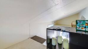 Ein kleines Zimmer mit Küchenzeile, einem Fenster und einer Tür.