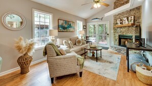 A spacious living room with a sofa, armchair, and a fireplace.