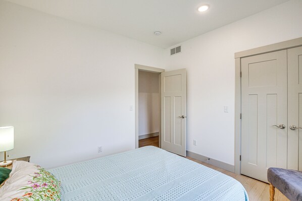 A bedroom with a bed, a nightstand, a bench, and a wardrobe. - Serene 1/3 Acre-families, Exec, Mayo (Pine Island)