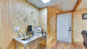 Ein Holzinterieur mit einer Metalltheke, einer weißen Tür und einem braunen Ledersessel.