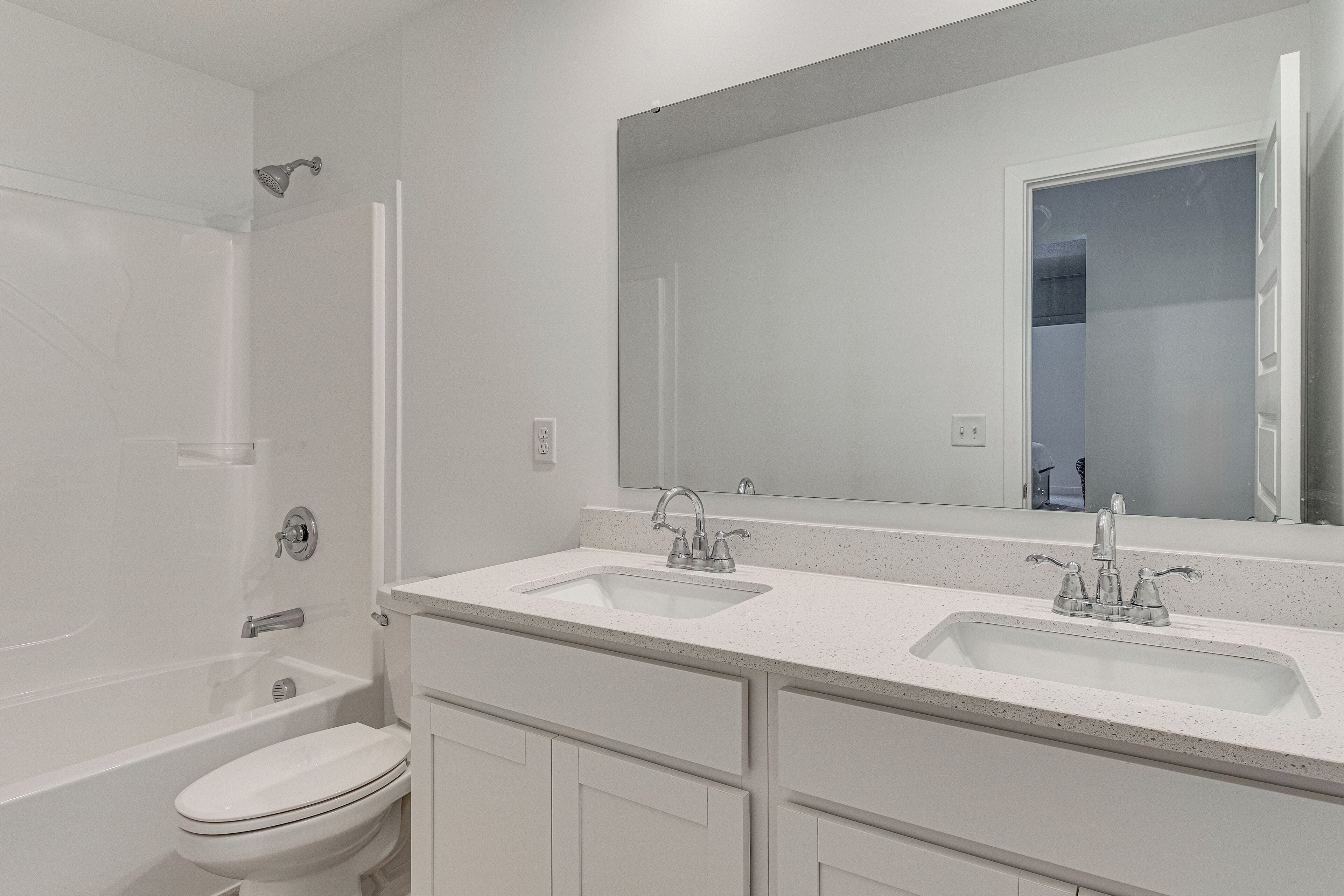 Un baño moderno con lavamanos doble, inodoro y ducha.