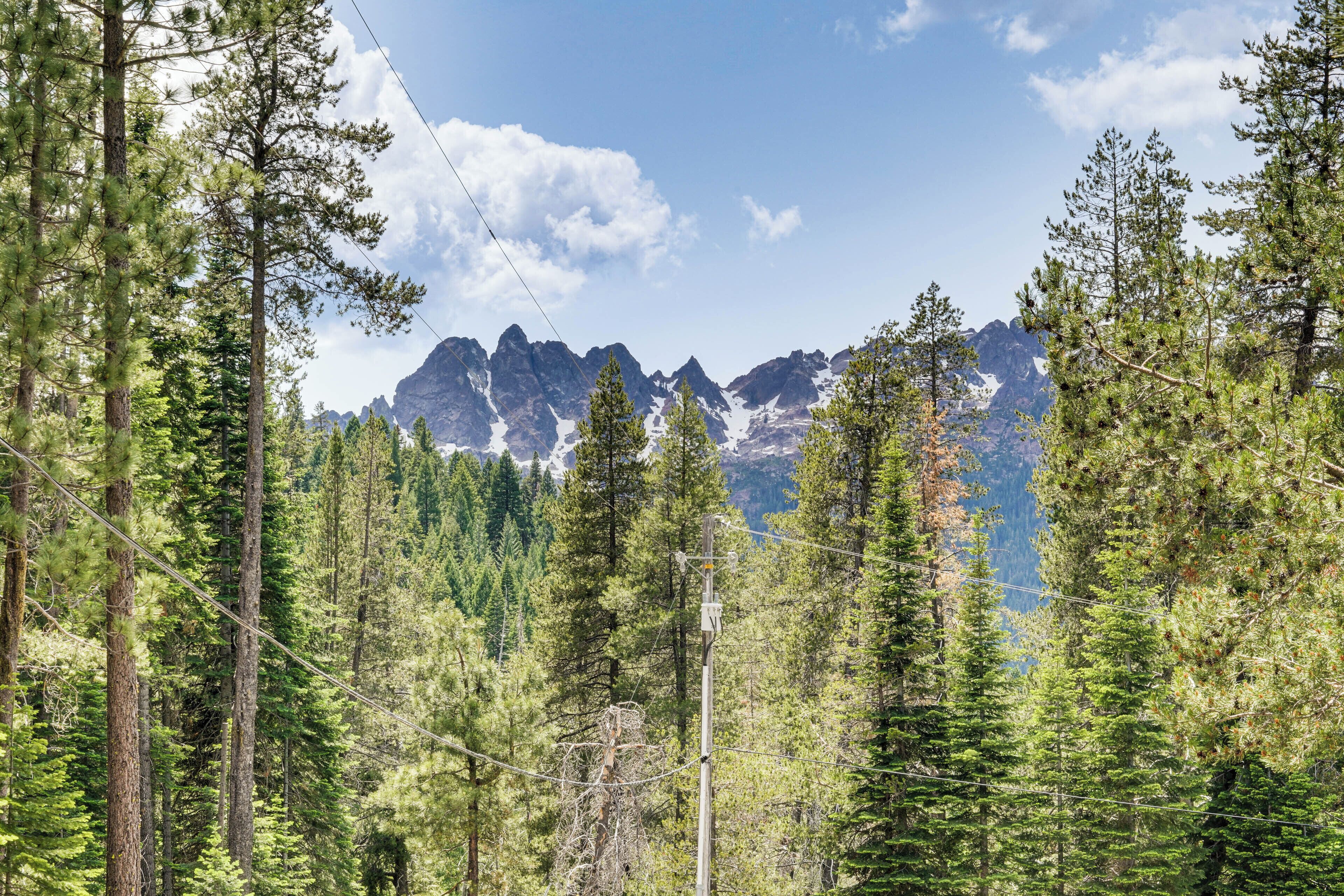 A forested mountain landscape with a clear sky.