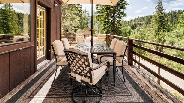 An outdoor patio with a table and chairs, a large umbrella, and a view of a forested area. - 6 Mi to Downieville Downhill: Cabin w/ Mtn Views (Sierra City)
