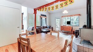 A cozy room with a wooden dining table, a sofa, and a fireplace. - 6 Mi to Downieville Downhill: Cabin w/ Mtn Views (Sierra City)