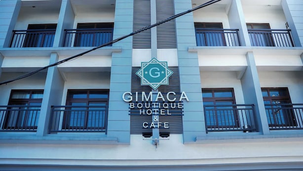 Un edificio con un cartel que dice 'GIMACA BOUTIQUE HOTEL & CAFE'.