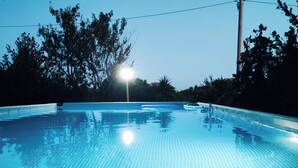 En swimmingpool med flisebelagt bund og en lyskilde i midten.