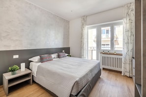 Laptop workspace, iron/ironing board, bed sheets
