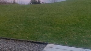 Udsigt over en sø med et picnicbord i forgrunden.