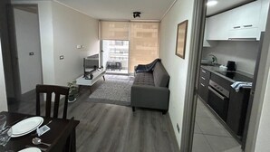 Un espace de vie compact comprenant un coin repas, une kitchenette et un canapé dans le salon.