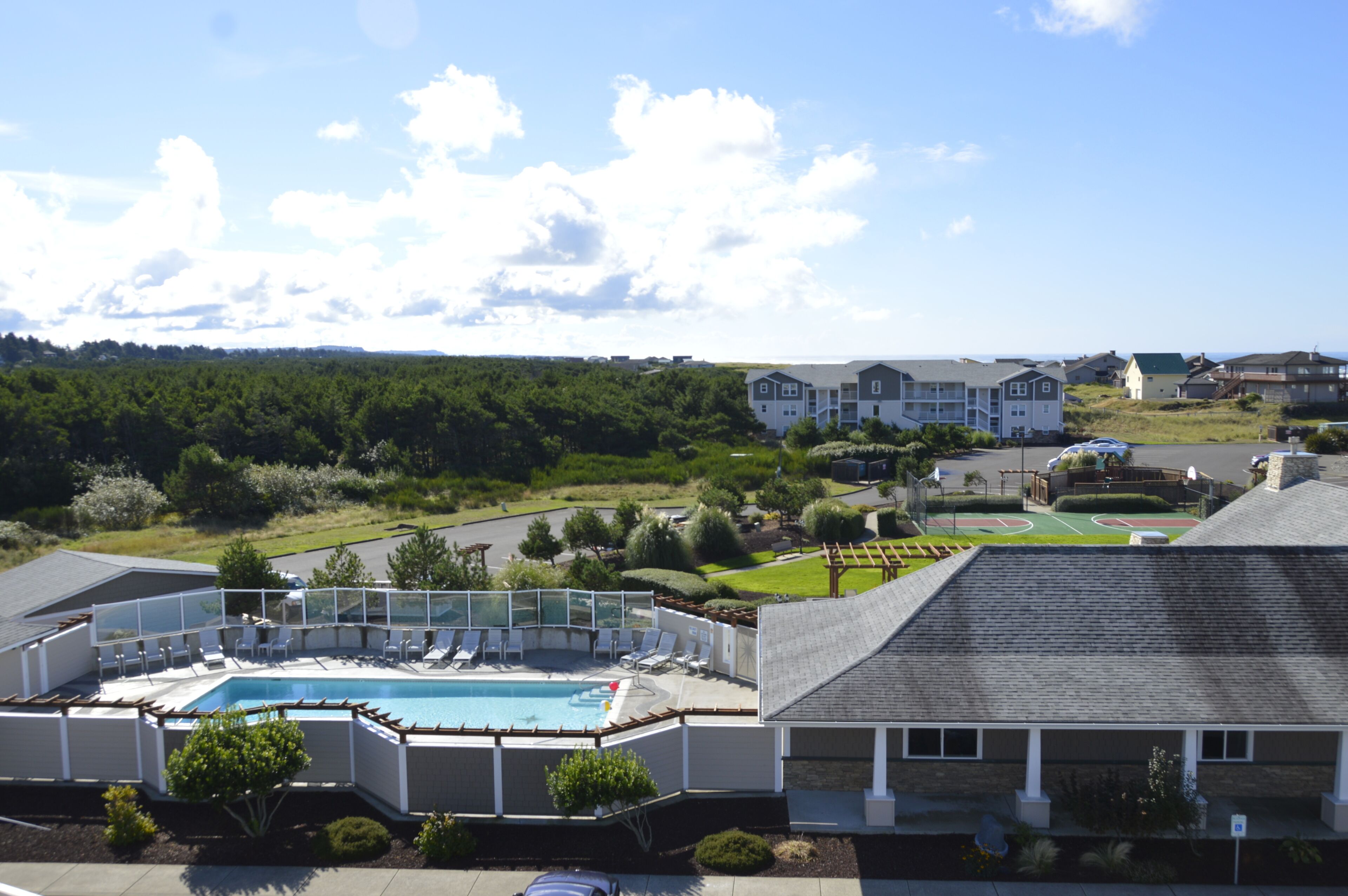 Et boligområde med swimmingpool, tennisbane og huse i baggrunden.