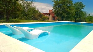 Une piscine rectangulaire à l’eau d’un bleu limpide, entourée d’une terrasse carrelée.