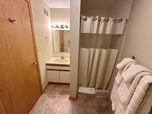 Een douche, handdoeken, zeep, toiletpapier