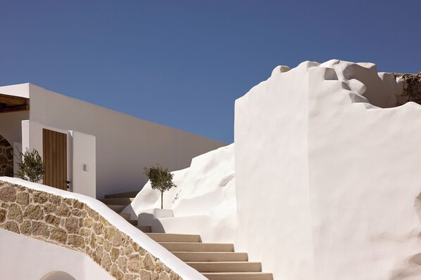A modern building with a stone staircase leading to a wooden door. - Villa Aethera Milos (Milos)