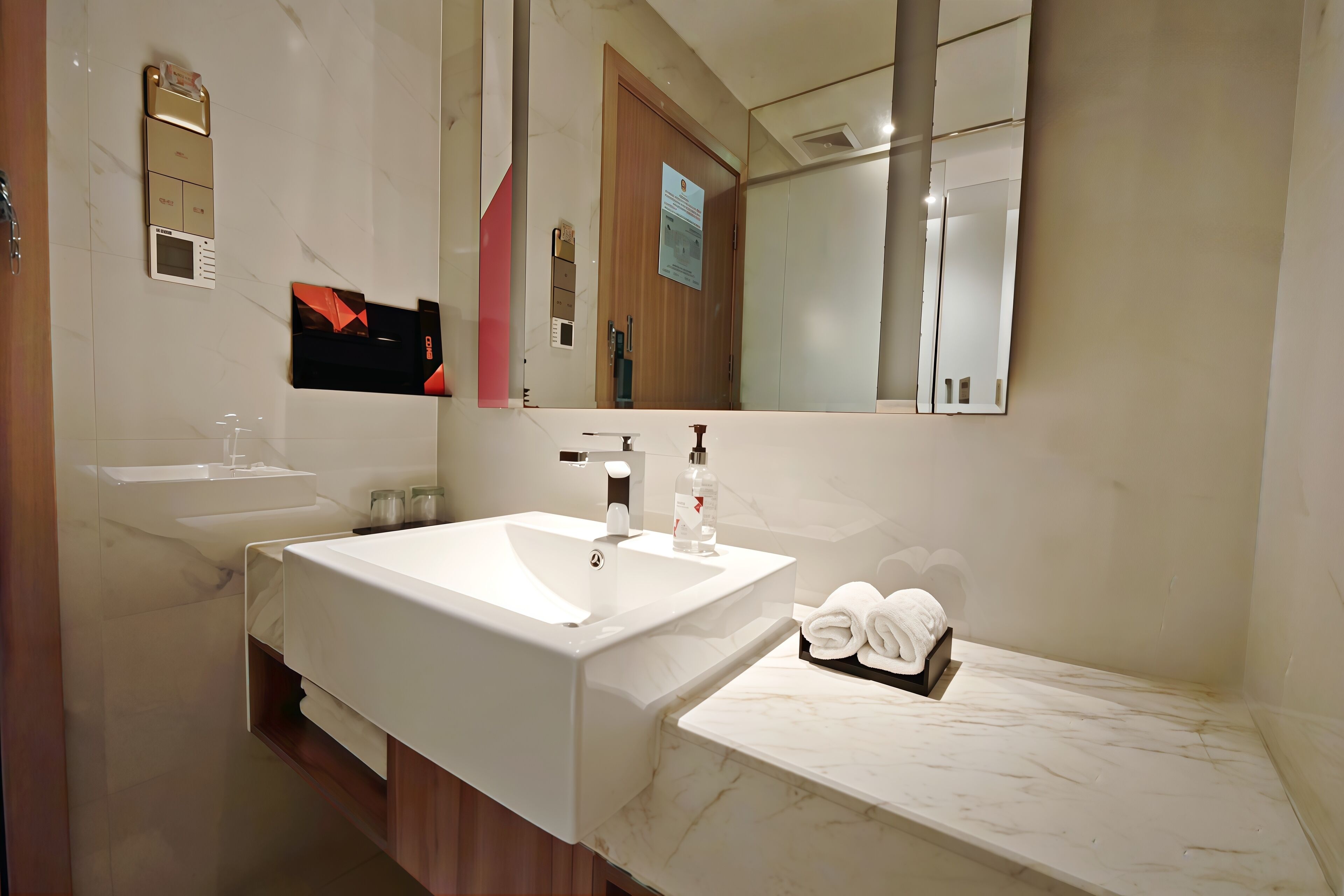 A modern bathroom with a large white sink, a mirror, and a towel rack.