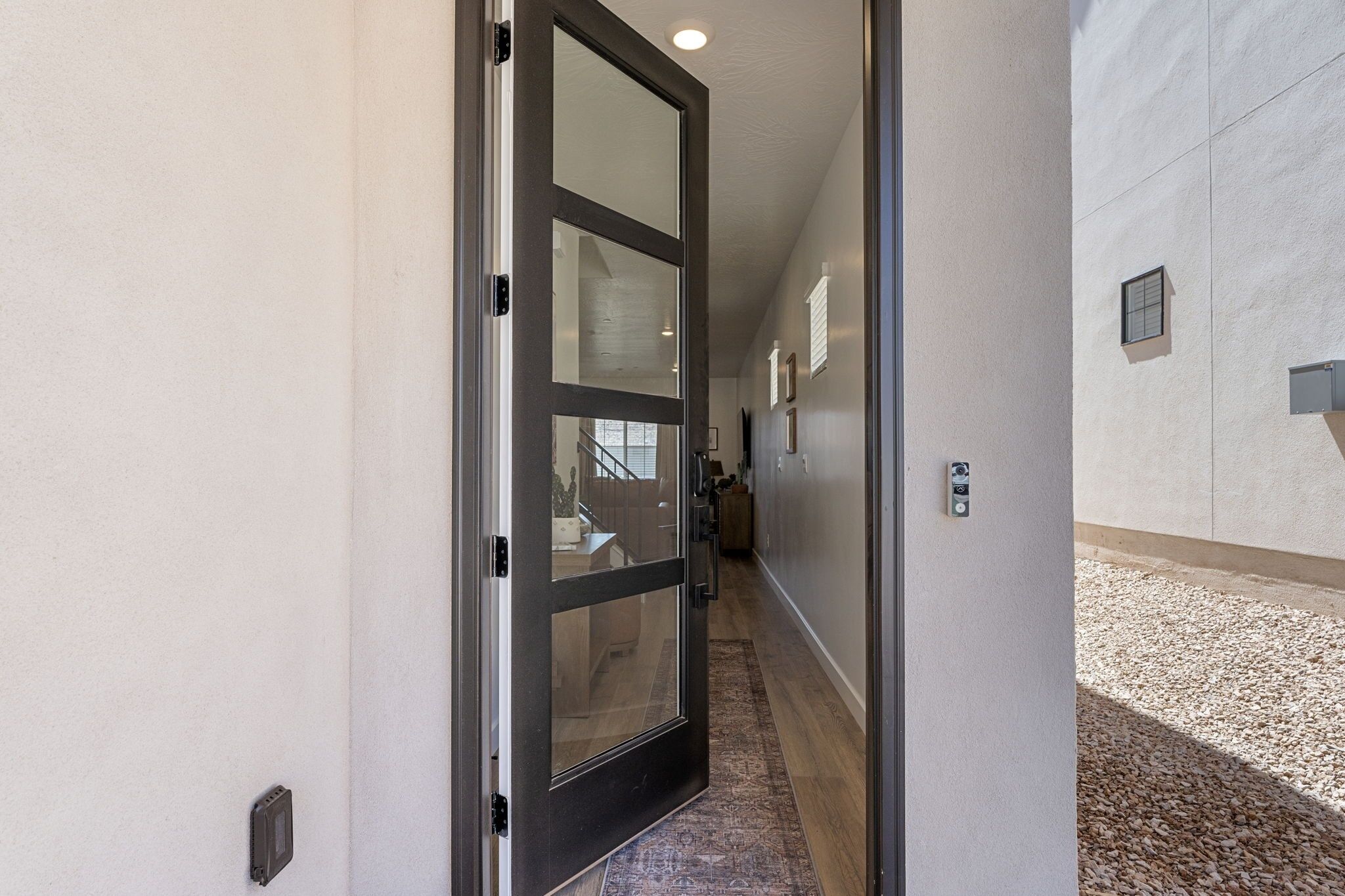 Un couloir avec une porte vitrée donnant sur un escalier.
