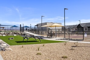 A fenced outdoor area with a picnic table, benches, and a covered seating area. - The Cactus Casa 4 Bedroom Townhouse (Washington)