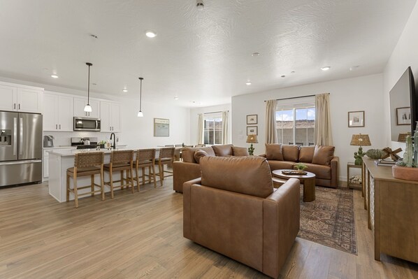 A spacious living area with a kitchen, a dining set, and a seating area with sofas and chairs. - The Cactus Casa 4 Bedroom Townhouse (Washington)