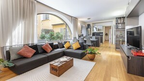 Una sala de estar moderna con un sofá modular, una mesa de centro y una televisión.
