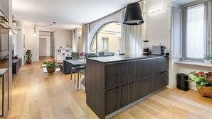 Un apartamento moderno con isla de cocina, comedor y sala de estar con un amplio ventanal.