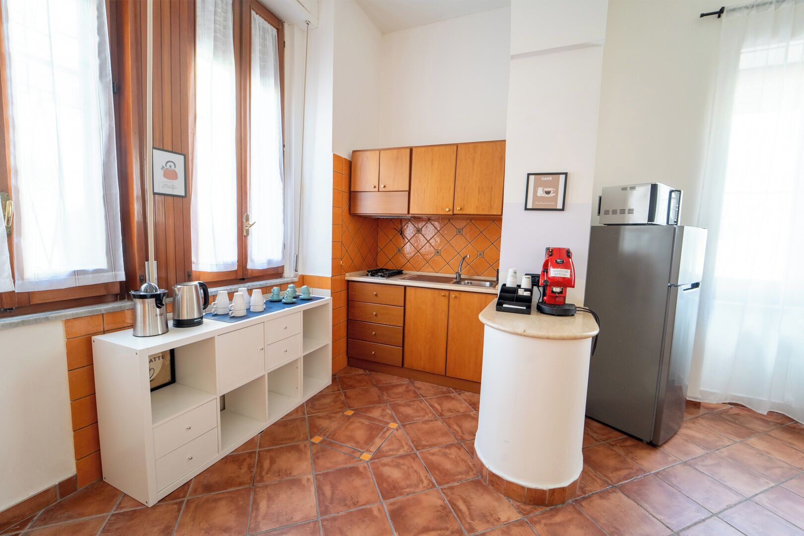 A compact kitchen with wooden cabinets, a built-in stove, and a refrigerator.