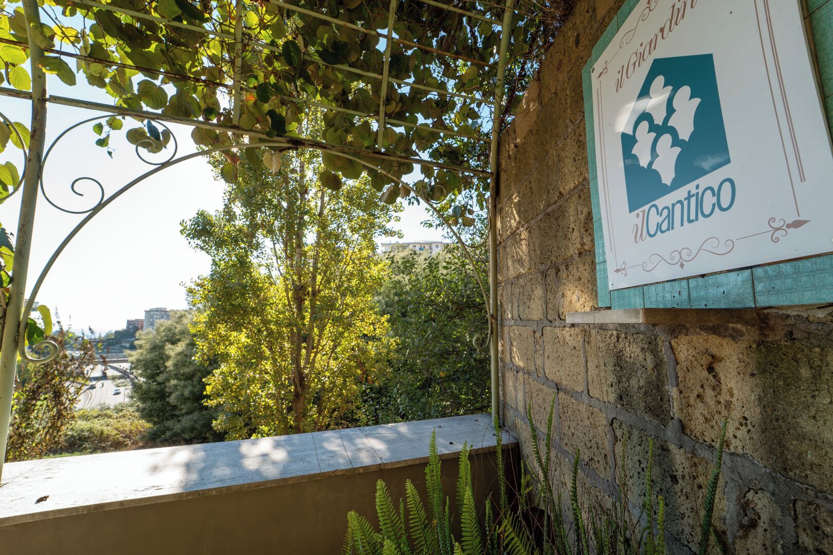 A stone wall with a sign that reads "Giardino Icantico".