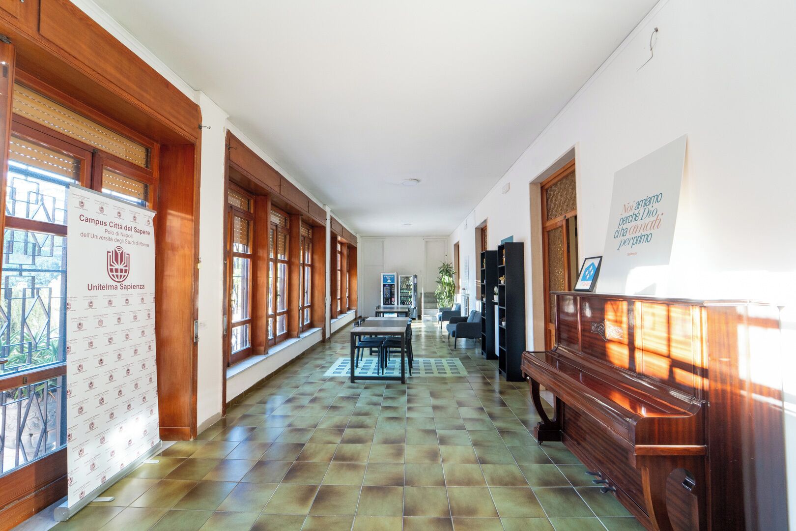 A corridor with wooden paneling, tiled flooring, and a piano.