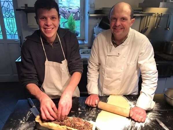 Two individuals in a kitchen preparing food, with a rolling pin and dough on the counter. - La Galotiere (Coteaux-sur-Loire)
