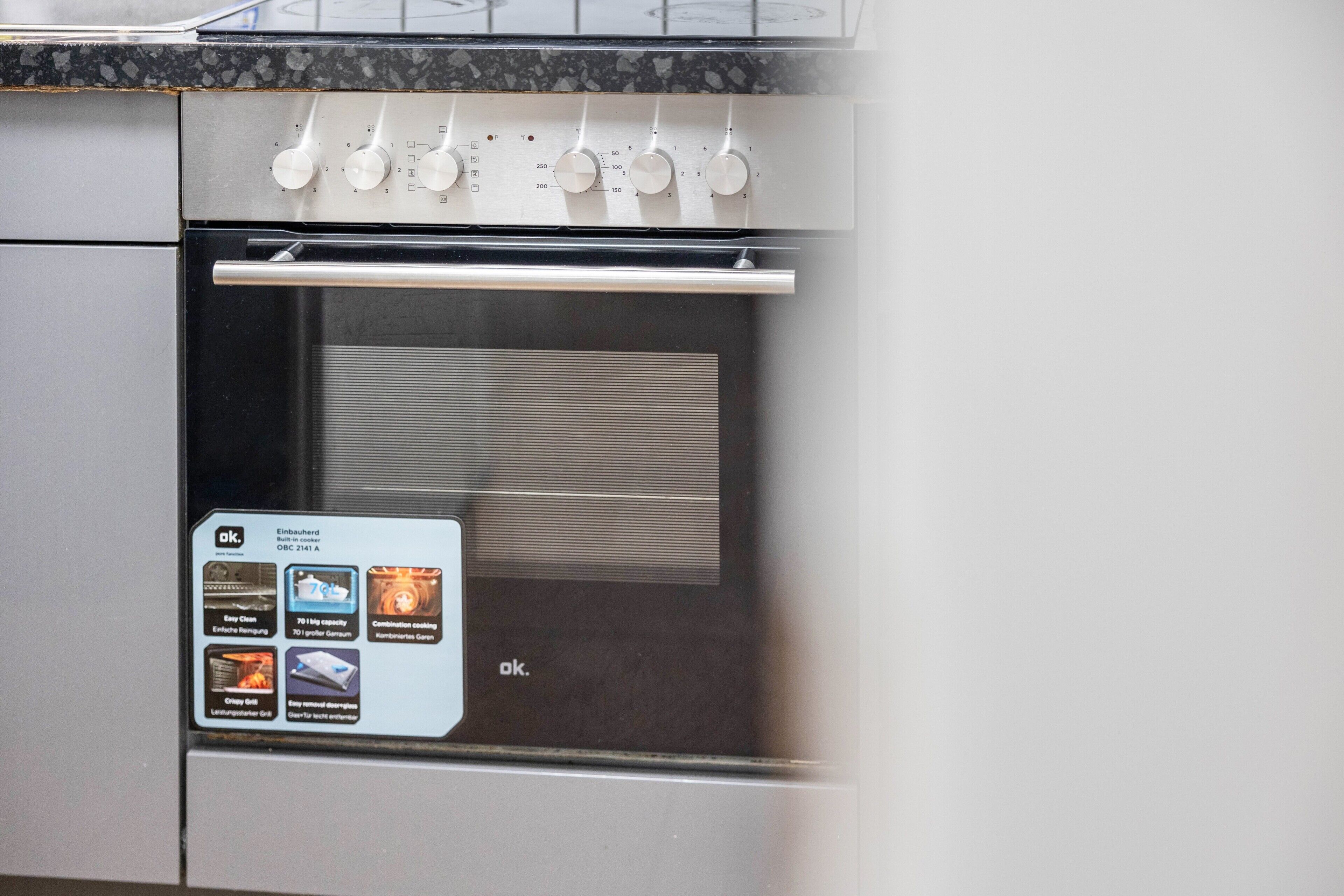 Una cocina con horno empotrado, salpicadero de acero inoxidable y panel de control con varias opciones.