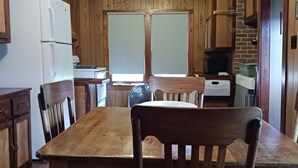 Cuina de fusta amb una illa central, armaris de fusta i un frigorífic.