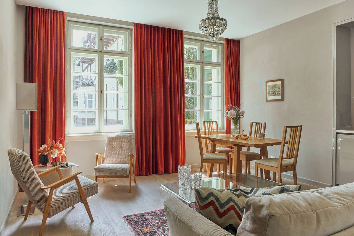 Una habitación luminosa con una mesa de comedor, sillas, un sofá y una araña.