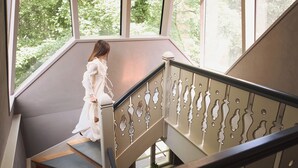 Une personne descendant un escalier muni d’une rampe ornée d’éléments décoratifs.