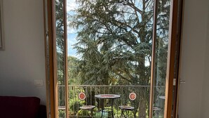 A room with a sliding glass door leading to an outdoor patio with a table and chairs. - Room-villa Casavecchia Caselli (Dicomano)