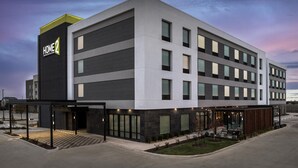 A modern hotel building with a flat roof, large windows, and a sign reading 'HOME 2'. - Home2 Suites By Hilton Taylor (Taylor)