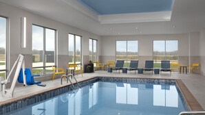 A swimming pool with clear blue water, surrounded by sun loungers and a lifeguard stand. - Hampton Inn By Hilton Dexter (Dexter)