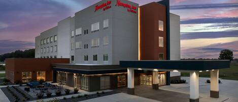 A Hampton Inn hotel with a modern design, featuring a flat roof and a prominent signage.
