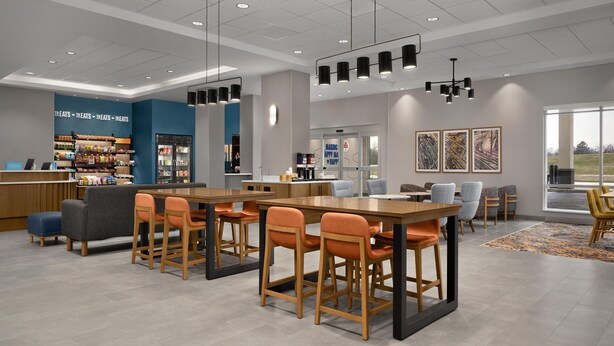A modern hotel lobby with a bar area, seating, and artwork on the walls. - Hampton Inn By Hilton Dexter (Dexter)