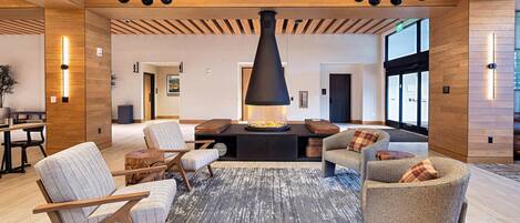 A modern interior with a fireplace, seating area, and wooden accents.