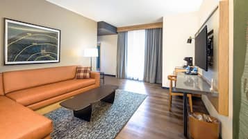 A modern living room with a sofa, coffee table, and a dining area with a table and chairs.