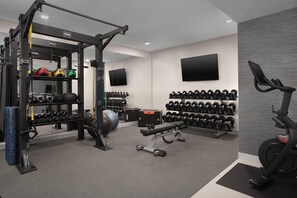 A gym with various exercise equipment, including a squat rack, dumbbells, and a stationary bike. - Homewood Suites By Hilton Portsmouth Downtown (Portsmouth)